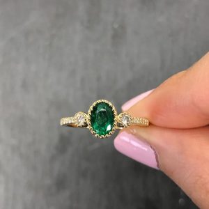 Oval Tsavorite 0.80cts ring set on 18 karat yellow gold with cubic zirconia